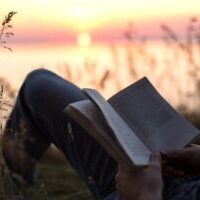 boy reading book at sunset