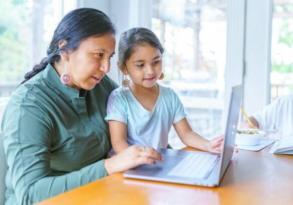 woman and girl in front of laptop